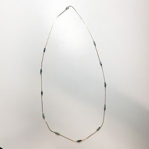 Delicate, gold-tone necklace with blue beads